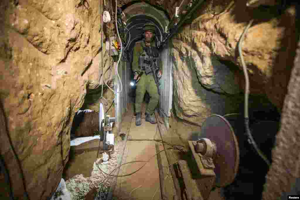 An Israeli army officer gives explanations to journalists during an army organized tour in a tunnel said to be used by Palestinian militants for cross-border attacks, July 25, 2014. 
