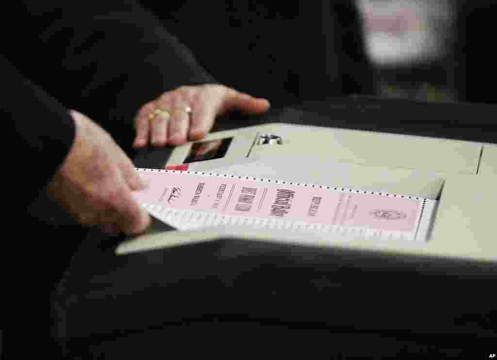 A ballot for the New Hampshire primary is entered into a machine at a polling site, Feb. 9, 2016, in Nashua, N.H.