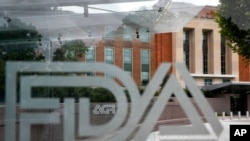 En esta imagen de archivo del jueves 2 de agosto de 2018, el edificio de la Administración estadounidense de Alimentos y Medicamentos se ve a través de mamparas con el logo de la institución en una parada de autobús en el campus de la agencia en Silver Spring, Maryland, EEUU.