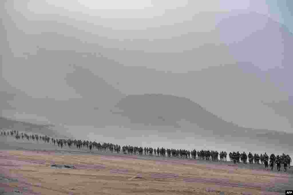 Competitors take part in the first stage of the 2nd Half Marathon of Sables Ica Desert-Peru, in Paracas, Peru, Dec. 2, 2019.