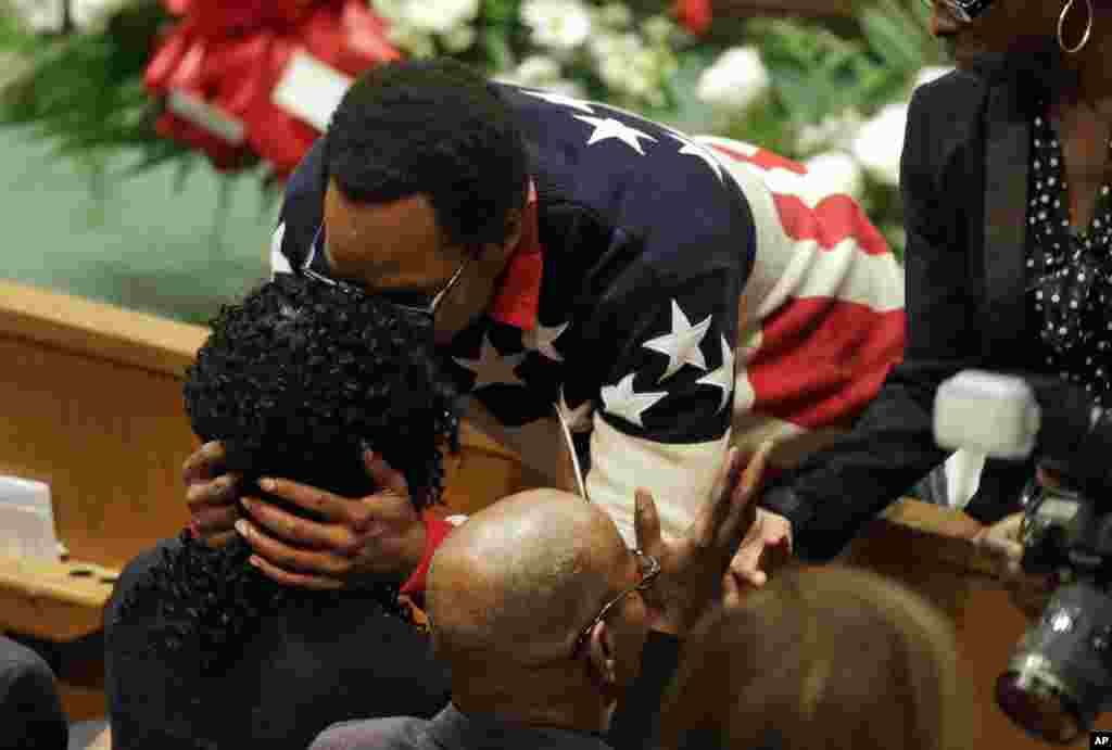 A mourner embraces Gloria Darden, left, mother of Freddie Gray, before Gray's funeral, in Baltimore, April 27, 2015.
