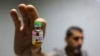 A worker shows a vial containing a polio vaccine provided with support from UNICEF to the Gaza Strip through the Karm Abu Salem crossing, also known as Kerem Shalom, at a depot belonging to Gaza's Health Ministry, Aug. 25, 2024.