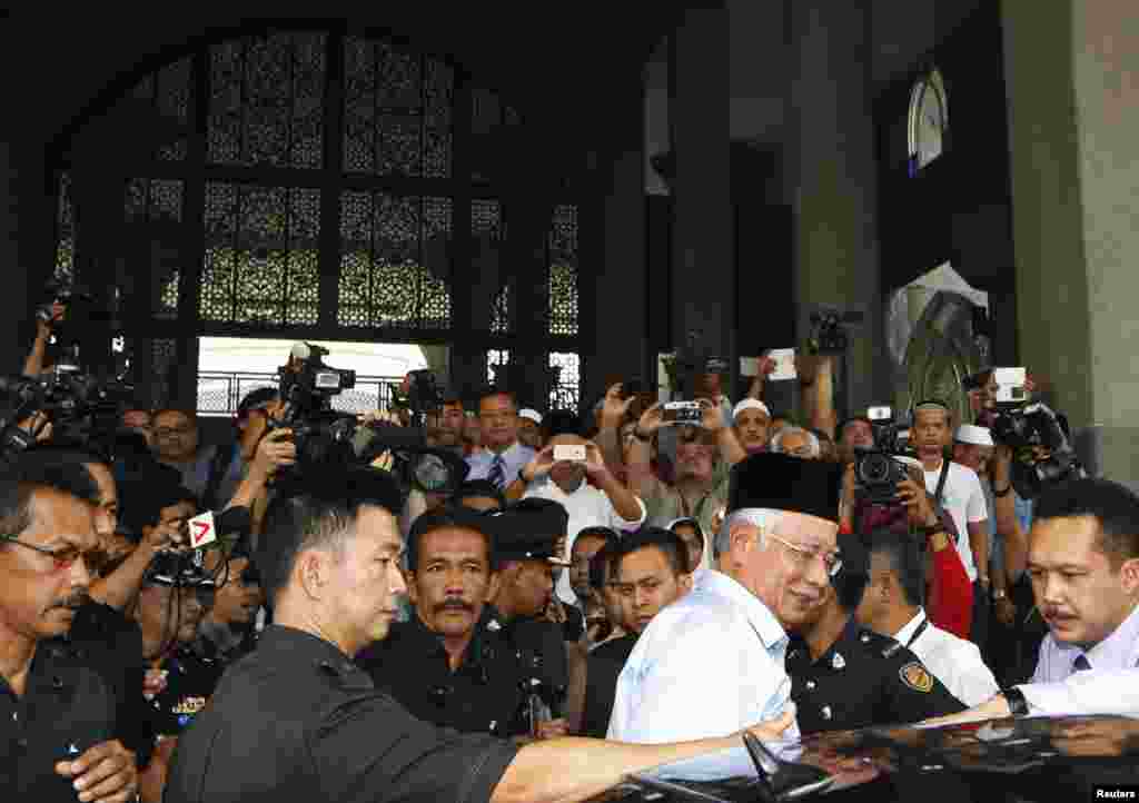 Thủ tướng Malaysia Malaysia Najib Razak rời khỏi một đền thờ gần sân bay Quốc tế Kuala Lumpur sau buổi cầu nguyện ngày thứ sáu dành cho các hành khách chuyến bay MH370.