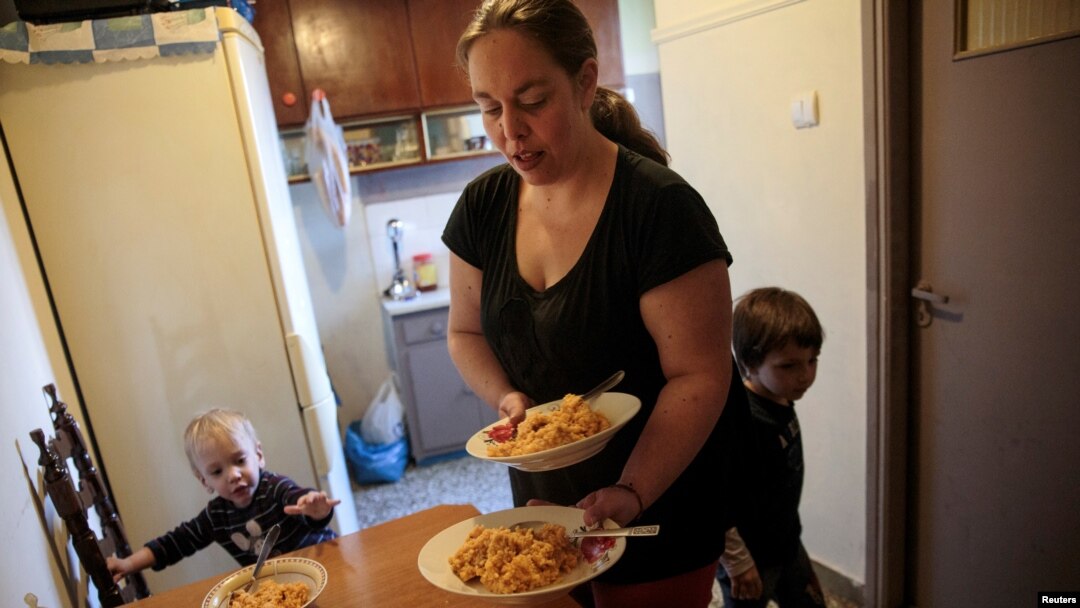 Olga Argyrou prepares to serve lunch to her children at the kitchen of her house at the suburb of Keratsini in Athens, Greece, March 27, 2017. 
