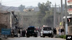 Security officials investigate the scene of a suicide car bomb attack, which killed and injured several people at the National Directorate of Security in Jalalabad, Afghanistan, February 24, 2013. 