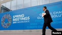 Archivo - Un hombre camina frente a la sede del Fondo Monetario Internacional en Washington, D.C., el 8 de abril de 2019.