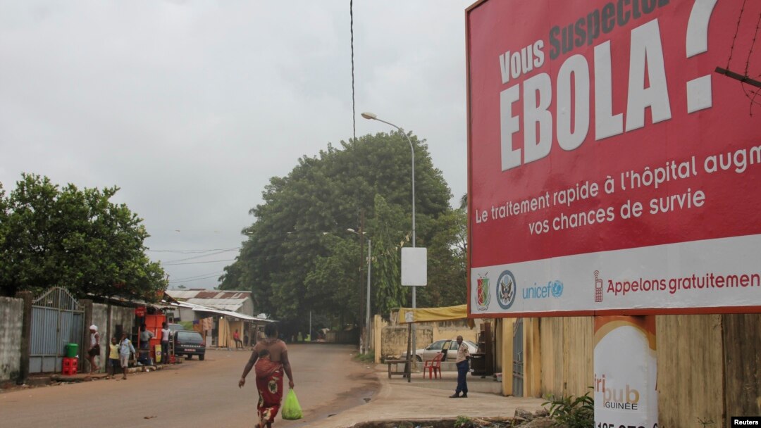 FILE - A billboard with a message about Ebola appears on a street in Conakry, Guinea, Oct. 26, 2014.