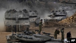 Israeli army tanks maneuver in a staging area in northern Israel near the Israel-Lebanon border, Oct. 1, 2024.