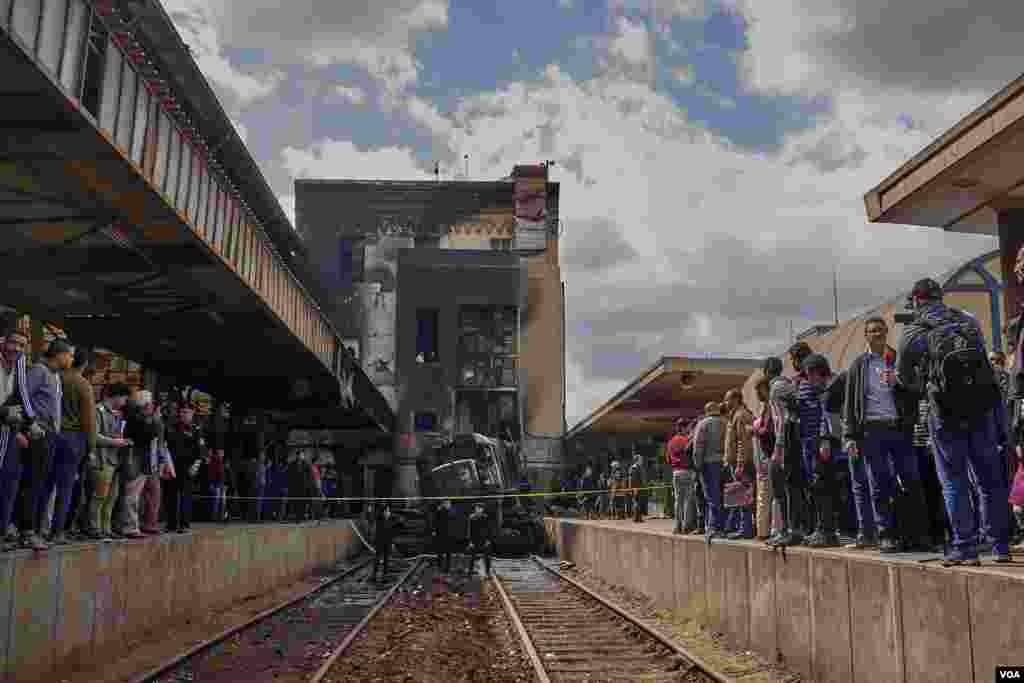Policemen guard the accident site as investigators arrive to inspect the scene for clues on why the locomotive, which crashed at high speed, failed to stop. (H. Elrasam/VOA)