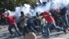 A tear gas canister, fired by the police, hits protesters during the clashes in front of the National Palace, in the center of Haitian capital Port-au-Prince, Feb. 13, 2019, on the sixth day of protests against Haitian President Jovenel Moise.
