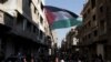 Pessoas assistem a um protesto organizado para celebrar o anúncio do cessar-fogo em Gaza, no campo de Yarmouk, em Damasco