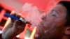 FILE - A customer puffs on an e-cigarette at the Henley Vaporium in New York City, Dec. 18, 2013.