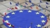 FILE - A large European Union flag lies at the center of Schuman Square outside European Commission headquarters in Brussels, Belgium, May 8, 2021. 