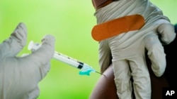 FILE - A health worker administers a dose of the Pfizer COVID-19 vaccine during a clinic at the Reading Area Community College in Reading, Pa., Sept. 14, 2021. 