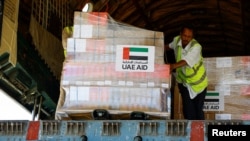 Wafanyakazi wakipakua mizigo kutoka Shirika la Afya Duniani(WHO) na msaada wa Umoja wa Falme za Kiarabu katika Uwanja wa Ndege wa Kimataifa wa Port Sudan, mji wa Port Sudan