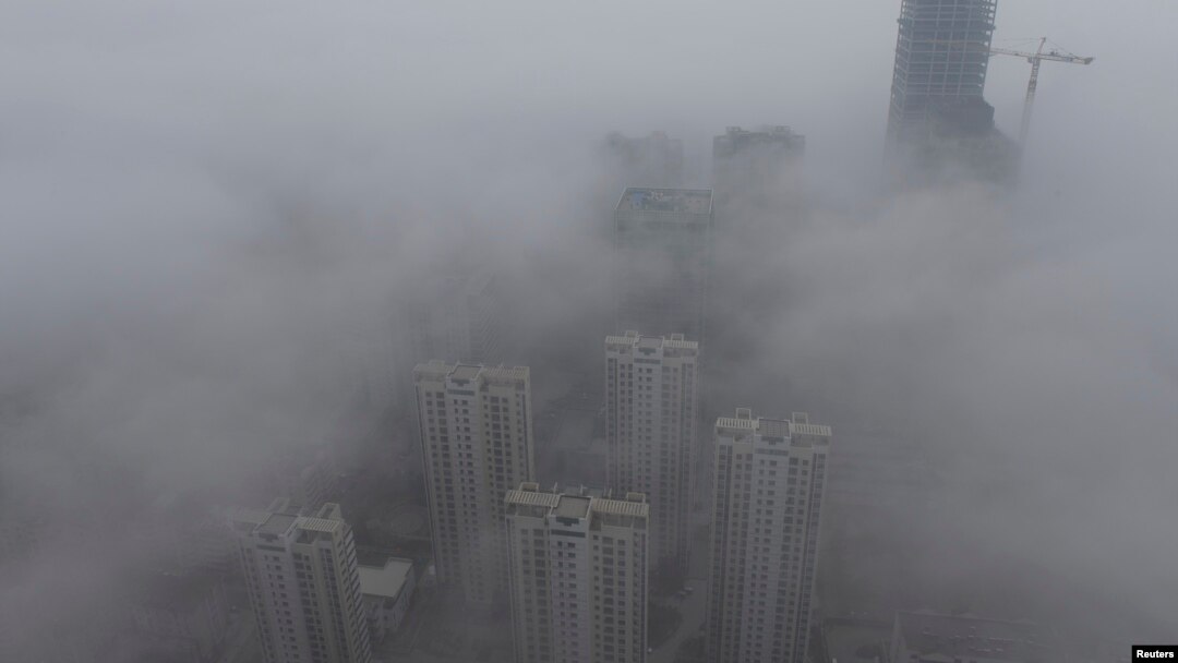 Buildings are seen shrouded in heavy haze at Qingdao development zone, Shandong province, Feb. 25, 2014. 