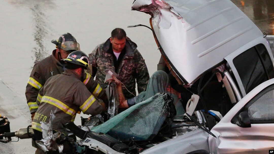 First responders work to free a passenger from a truck involved in an accident on Interstate Highway 35 during severe weather in Moore, Okla., May 6, 2015. 