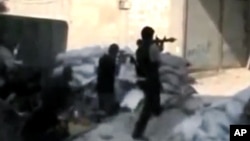 This image made from amateur video released by the Ugarit News, July 15, 2012, purports to show Free Syrian Army soldiers clashing with government forces in Damascus. (AP cannot independently verify the content, date, location or authenticity of this mate