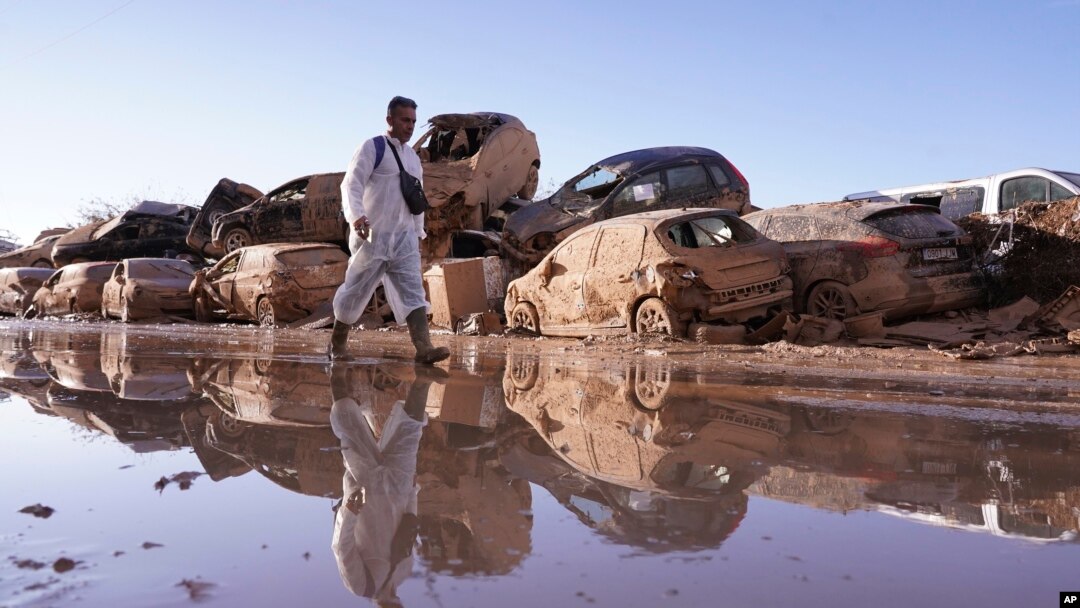 Un hombre camina al lado de automóviles apilados tras las inundaciones en Catarroja, Valencia, España, el 12 de noviembre de 2024. (AP/Alberto Saiz)