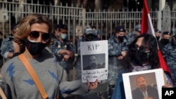 Anti-Hezbollah protesters hold pictures of Lokman Slim, a longtime Shiite political activist and researcher, who was found dead in his car, during a protest in front of the Justice Palace in Beirut, Lebanon, Feb. 4, 2021.
