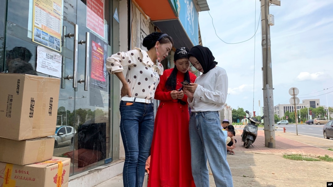 Women from the the Hui Muslim ethnic minority from a nearby neighborhood gather outside a shop near an OFILM factory in Nanchang in eastern China's Jiangxi province, June 5, 2019.