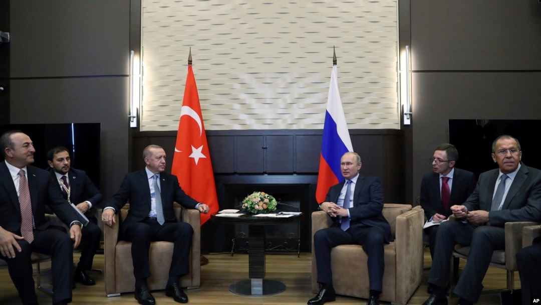 Russian President Vladimir Putin, center right, and Turkish President Recep Tayyip Erdogan , center left, speak during their meeting in the Bocharov Ruchei residence in the Black Sea resort of Sochi, Russia, Oct. 22, 2019.
