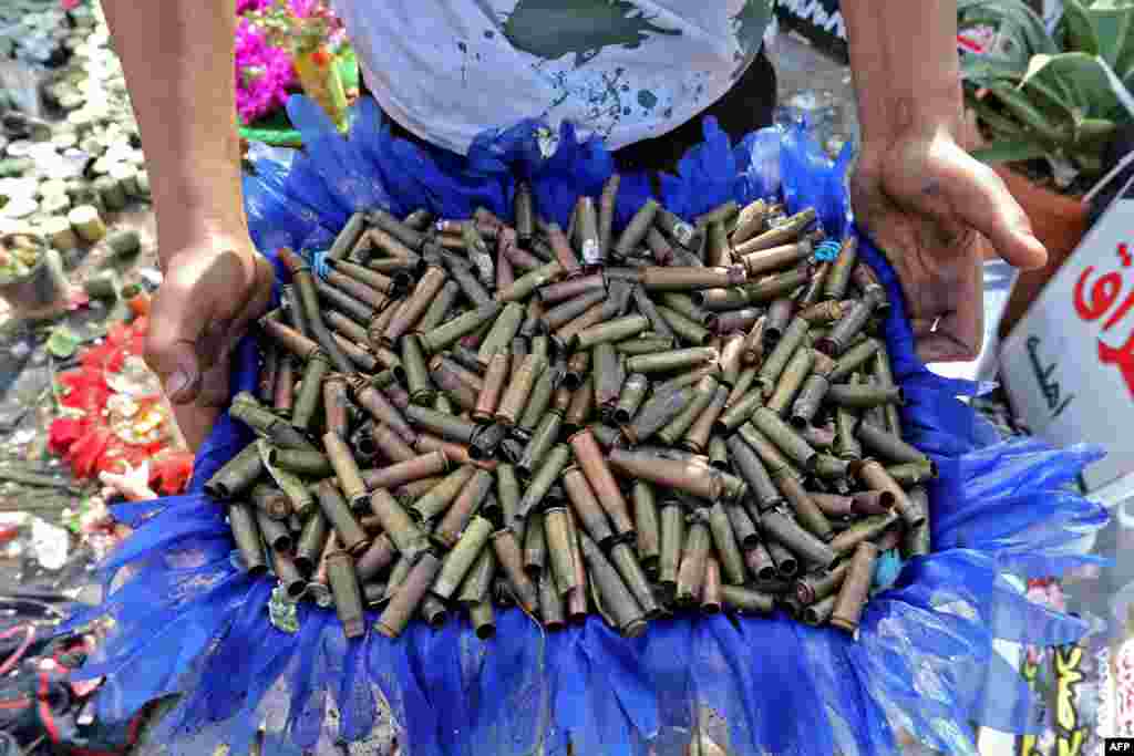 An Iraqi anti-government demonstrator shows a basket full of empty bullet cartridges found in the capital Baghdad's Tahrir Square.