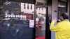 FILE - People pass the electoral office of Australian federal Labor Party member of parliament Josh Burns in the Melbourne suburb of St. Kilda after police said at least five people smashed windows and painted slogans on the walls on June 19, 2024.