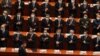 Los delegados que usan máscaras para ayudar a frenar la propagación del coronavirus aplauden cuando el presidente chino, Xi Jinping, llega a la sesión de apertura del Congreso en el Gran Salón del Pueblo, el 4 de marzo de 2021. 