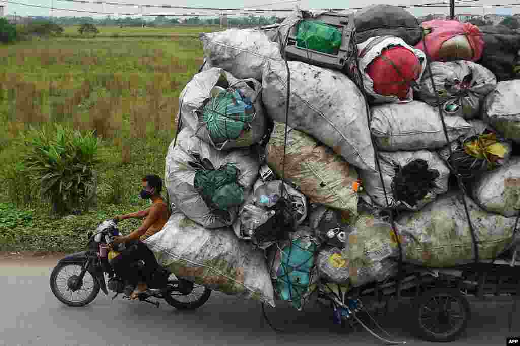 Waste collectors transport plastic scrap for recycling in the suburbs of Hanoi, Vietnam.