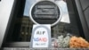 FILE - Tributes are placed beneath the covered seal of the U.S. Agency for International Development (USAID) at its headquarters in Washington, Feb. 7, 2025.